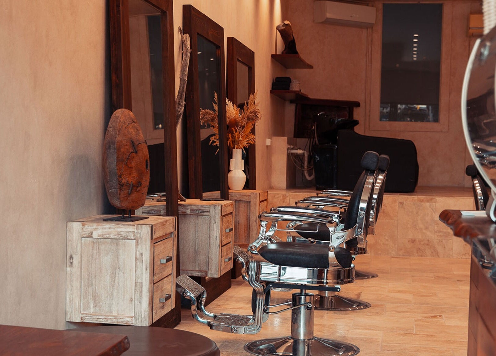 Stylish interior of Waves Barbershop in West End, Queensland, AU, featuring vintage barber chairs and wooden decor.