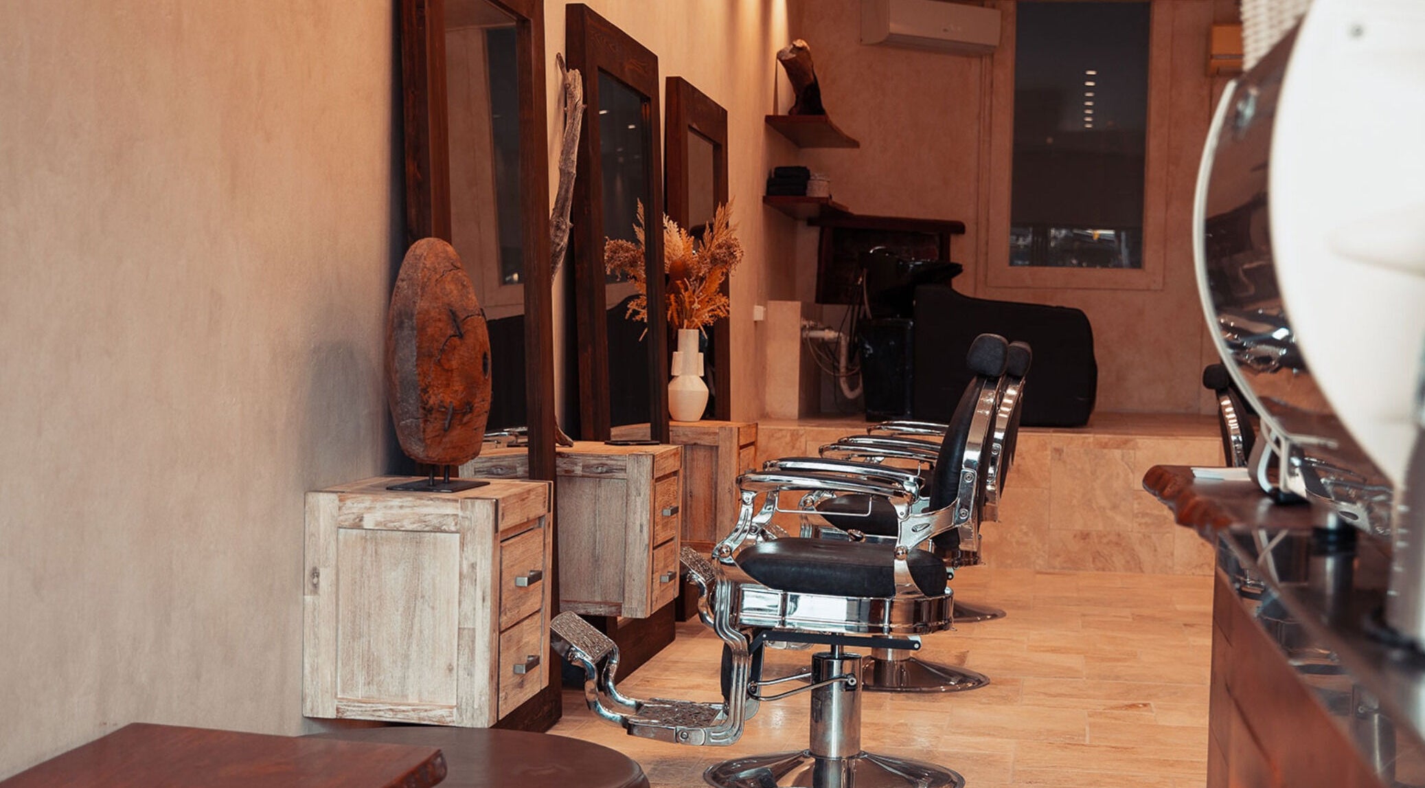 Stylish interior of Waves Barbershop in West End, Queensland, AU, featuring vintage barber chairs and wooden decor.