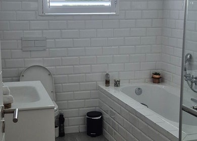 Pristine white-tiled bathroom at Equilibrium Beauty Salon, Cape Town, Western Cape, ZA. Modern and soothing design.