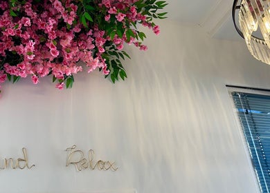 Elegant chandelier and pink blossoms at Chloe Louise Beauty, Lossiemouth, Scotland, GB, enhancing relaxation.