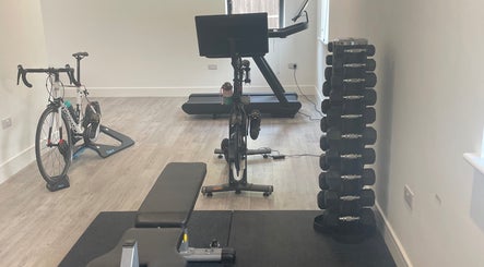Fitness area at Kineto Clinic, Vann Common, Fernhurst, England featuring gym equipment and weights.