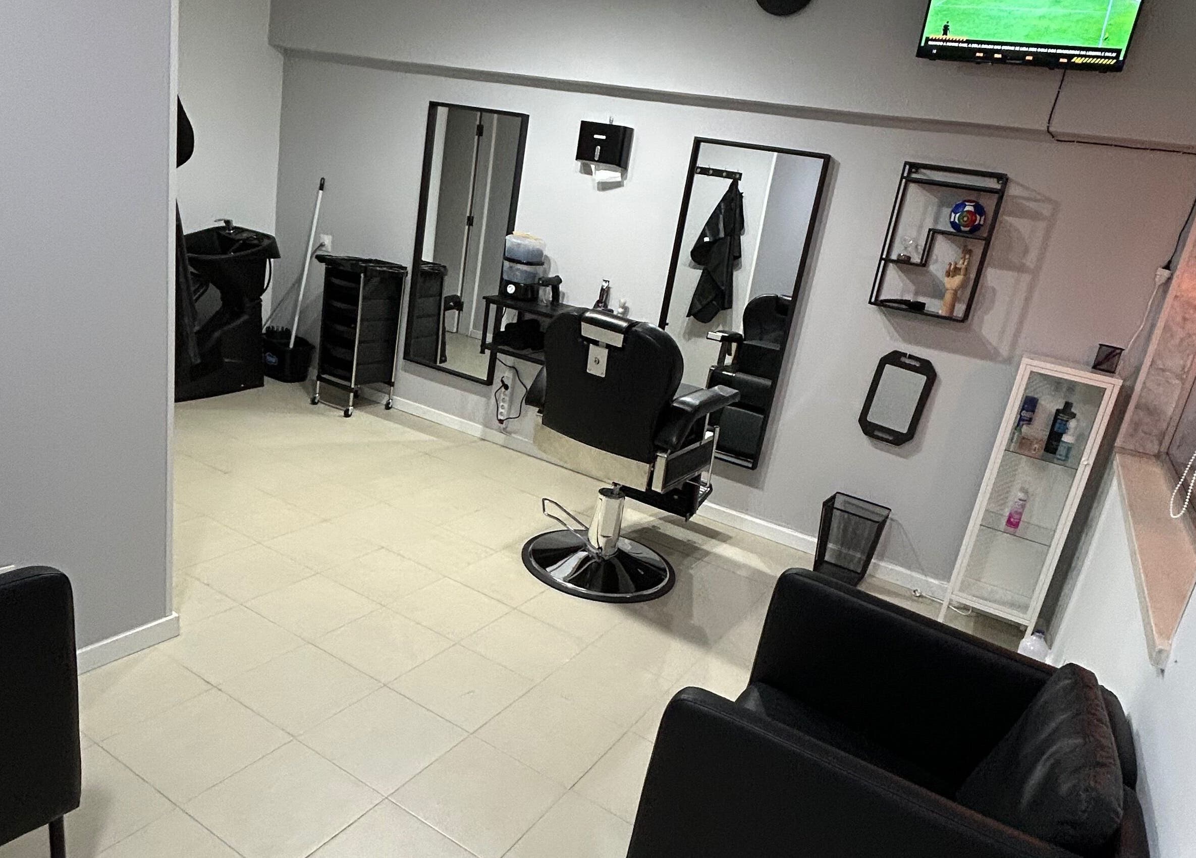 Espaço interior de Bronk's Barbearia em Fernão Ferro, Setúbal, PT com cadeira de barbeiro e espelhos modernos.