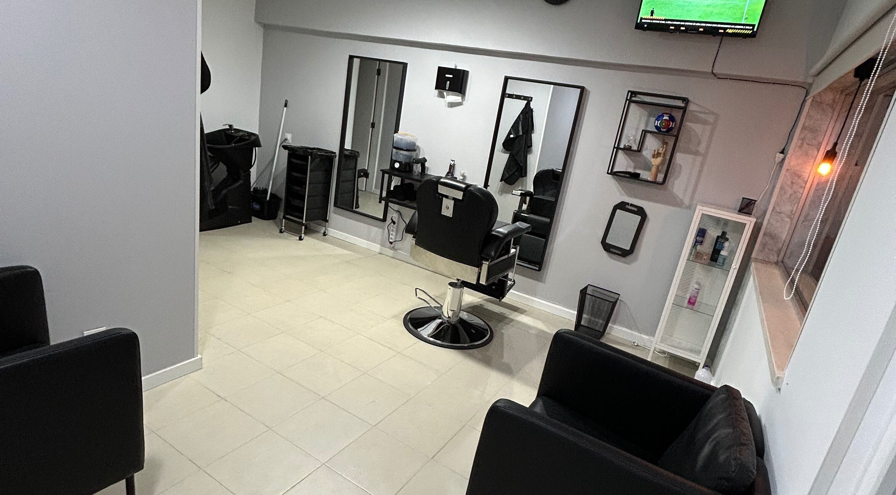 Espaço interior de Bronk's Barbearia em Fernão Ferro, Setúbal, PT com cadeira de barbeiro e espelhos modernos.