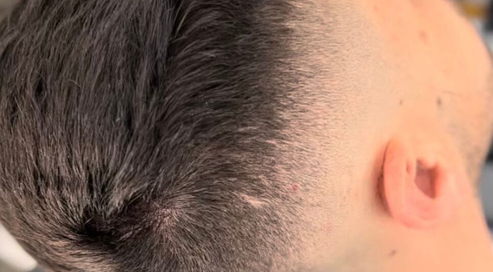 Corte de cabelo moderno em Bronk's Barbearia, Fernão Ferro, Setúbal, PT, destacando técnica fade.