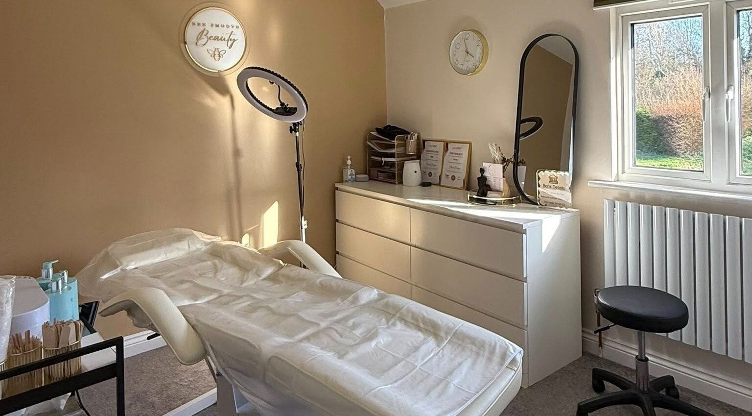 A calming treatment room at Bee Smooth Beauty, Tonbridge, England, GB, with a massage table and warm decor.