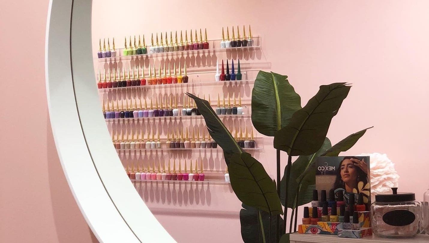 Stylish nail polish display at Emily House Nail on Dundas, Toronto, Ontario, CA with lush plant accents.