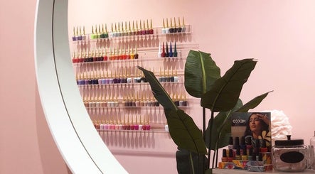 Stylish nail polish display at Emily House Nail on Dundas, Toronto, Ontario, CA with lush plant accents.