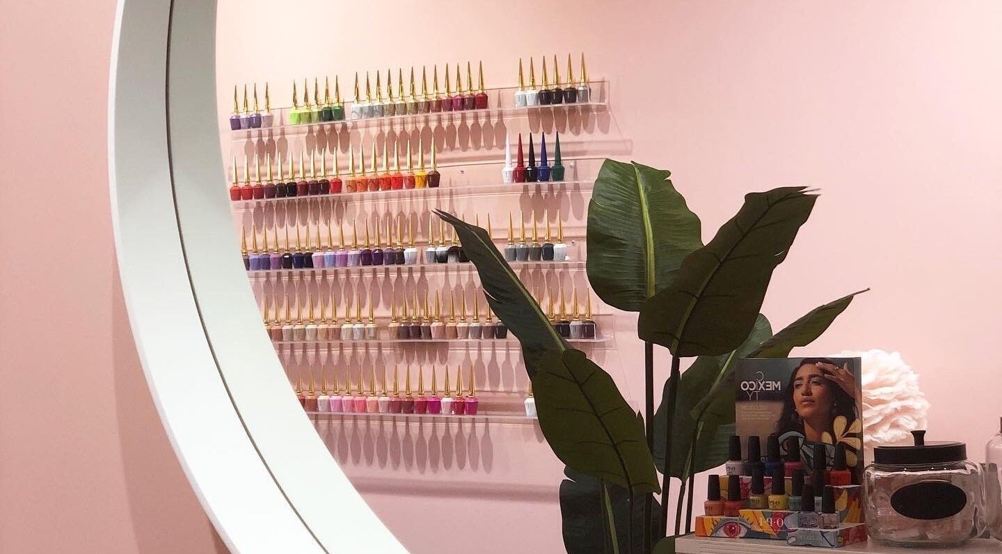 Stylish nail polish display at Emily House Nail on Dundas, Toronto, Ontario, CA with lush plant accents.