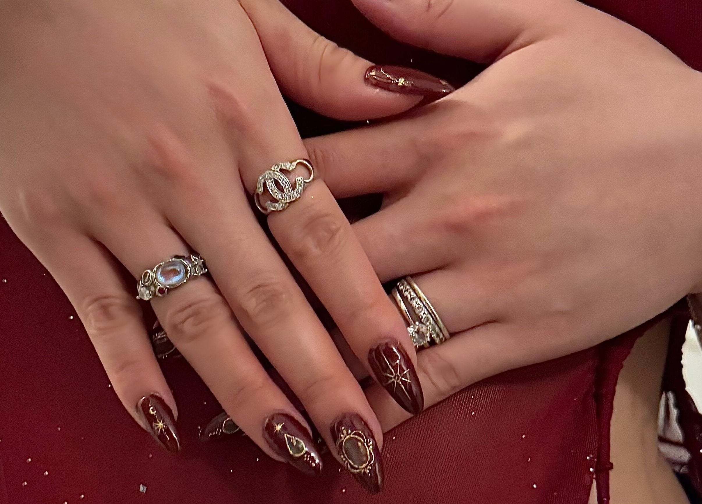 Elegant maroon nail art with rings at Afterglow Esthetics Lab, Toronto, Ontario, CA.