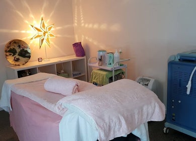Treatment room at Touch of Grace Beauty, Morningside, Queensland, AU, featuring a massage table and ambient lighting.