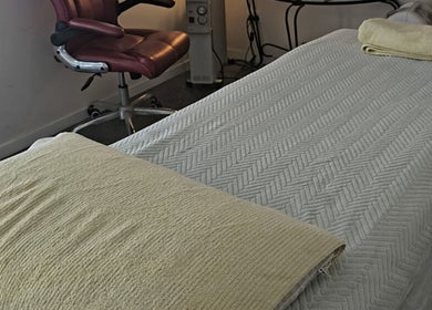 Calming spa room at Touch of Grace Beauty, Morningside, Queensland, AU with plush bed and cozy chair.