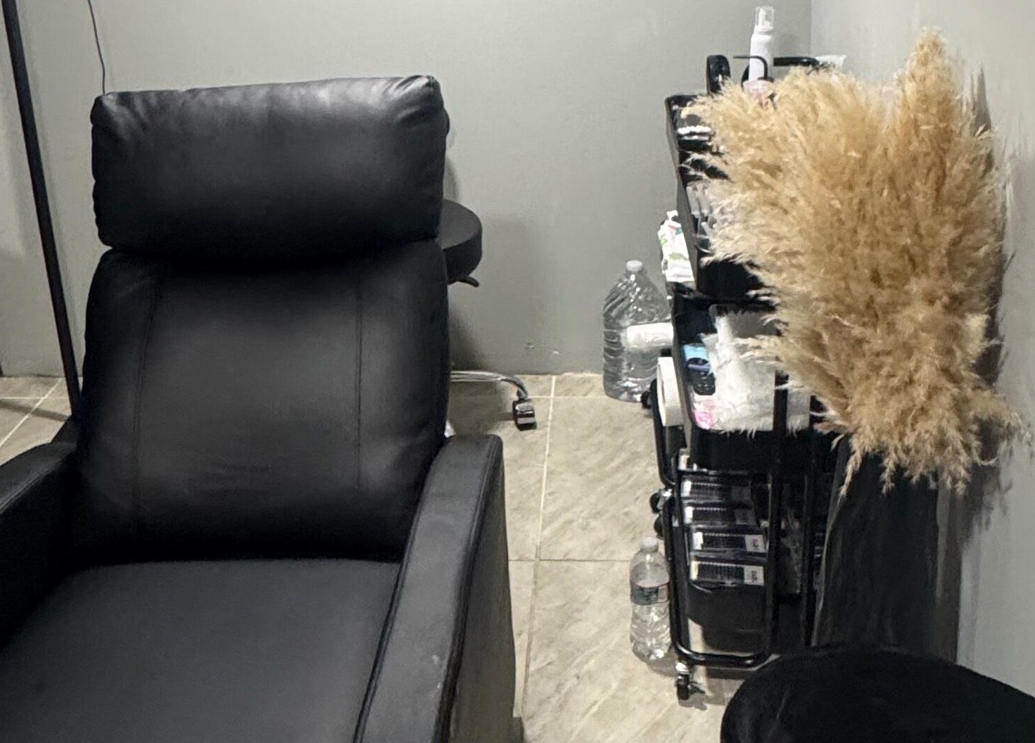 Sala de belleza en Darg Lashes, Rahway, New Jersey, US, con cómoda silla negra y estante de suministros.