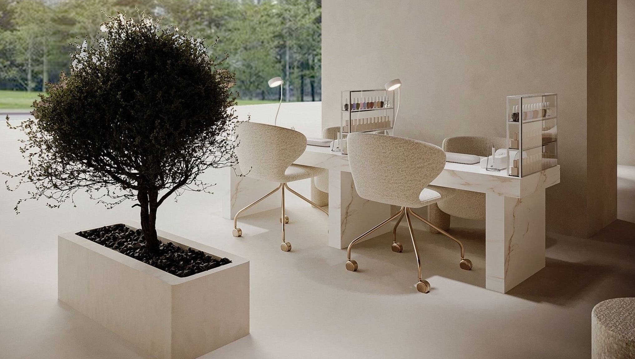 Elegant nail station at Golden Glow Beauty Lounge, Dubai, Dubai, AE with marble table and plush chairs.