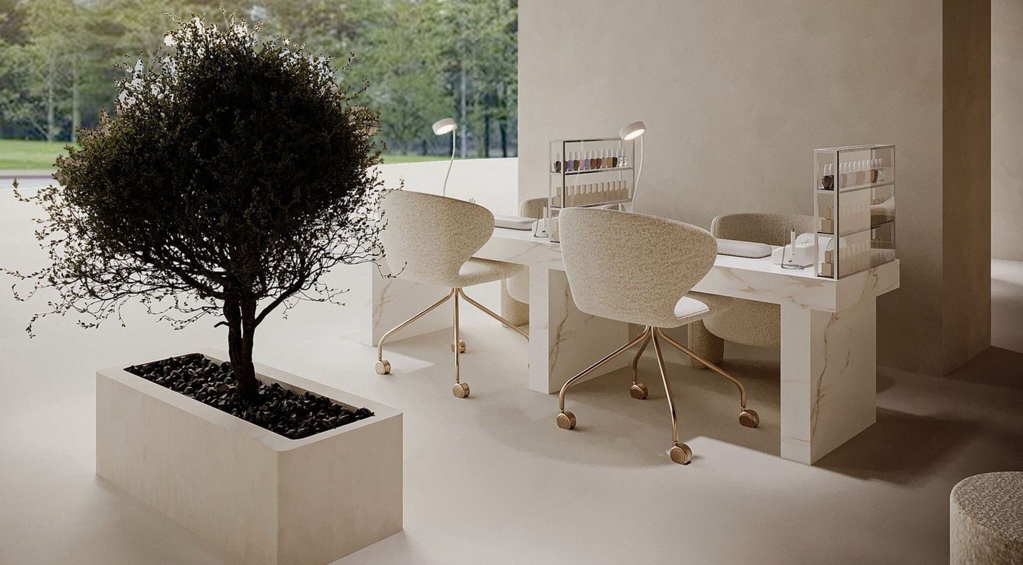 Elegant nail station at Golden Glow Beauty Lounge, Dubai, Dubai, AE with marble table and plush chairs.