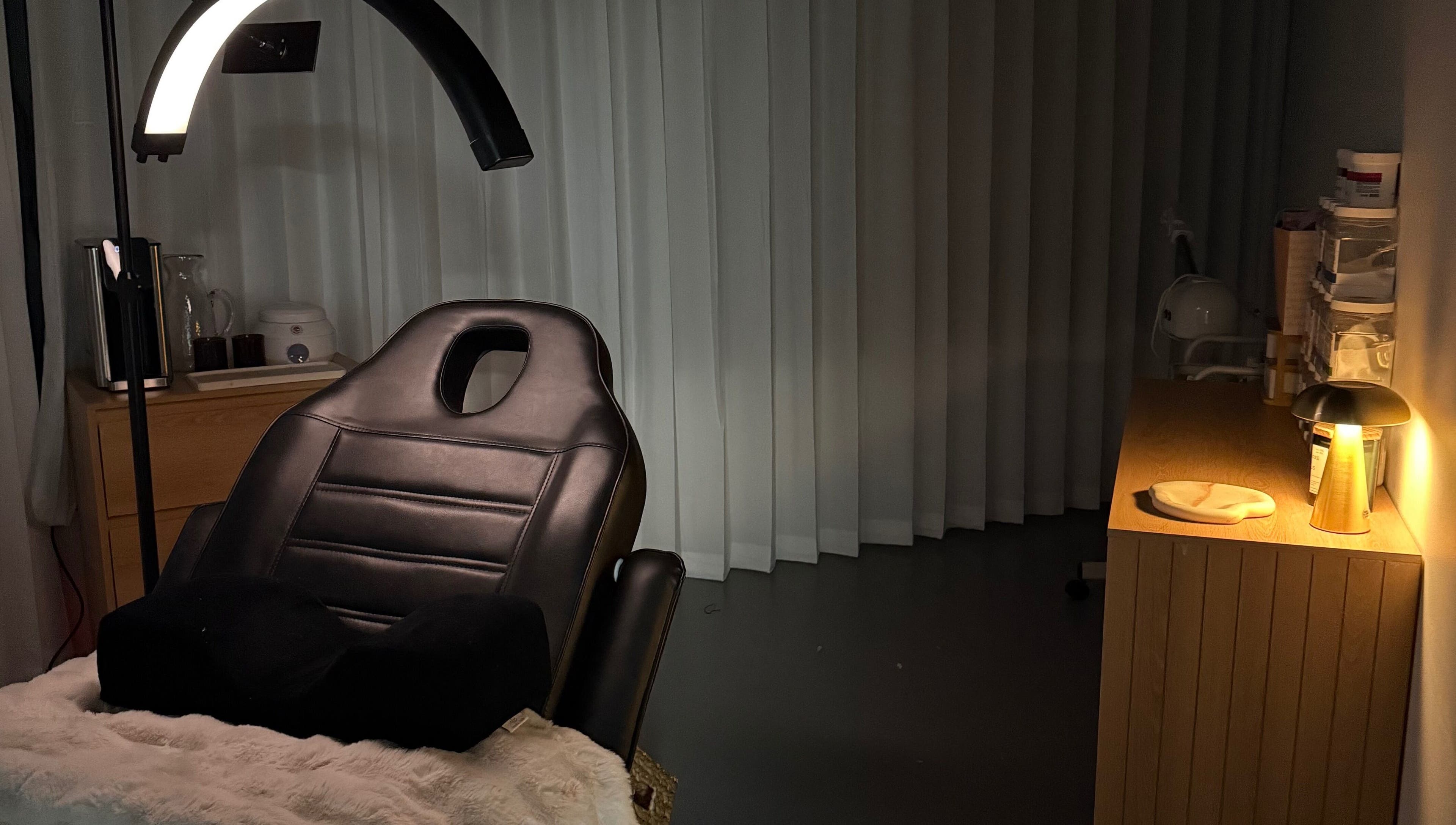 A tranquil treatment room at Linèa Beauty in Acacia Ridge, Queensland, AU, featuring a reclining chair and soft lighting.