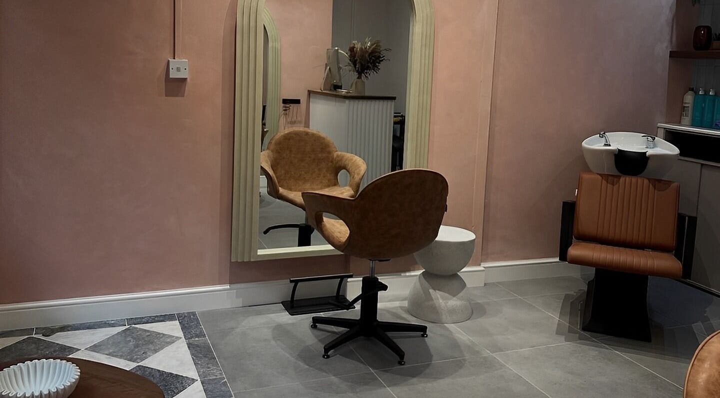 Elegant salon chair and mirror at Crear Hair & Beauty in Cardiff, Wales, GB showcasing modern interior design.