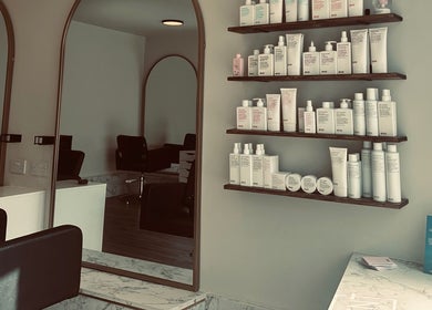 Stylish salon interior at Colbydoeshair @ Salon Twenty Two, Darlington, England, GB, with products on shelves.