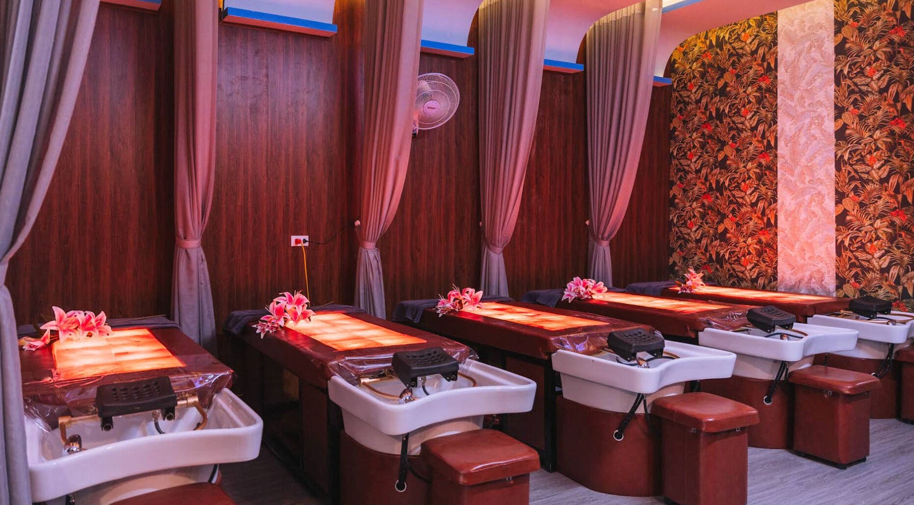 Luxurious massage tables at Solis Spa, Đà Nẵng, VN, adorned with flowers and warm lighting.