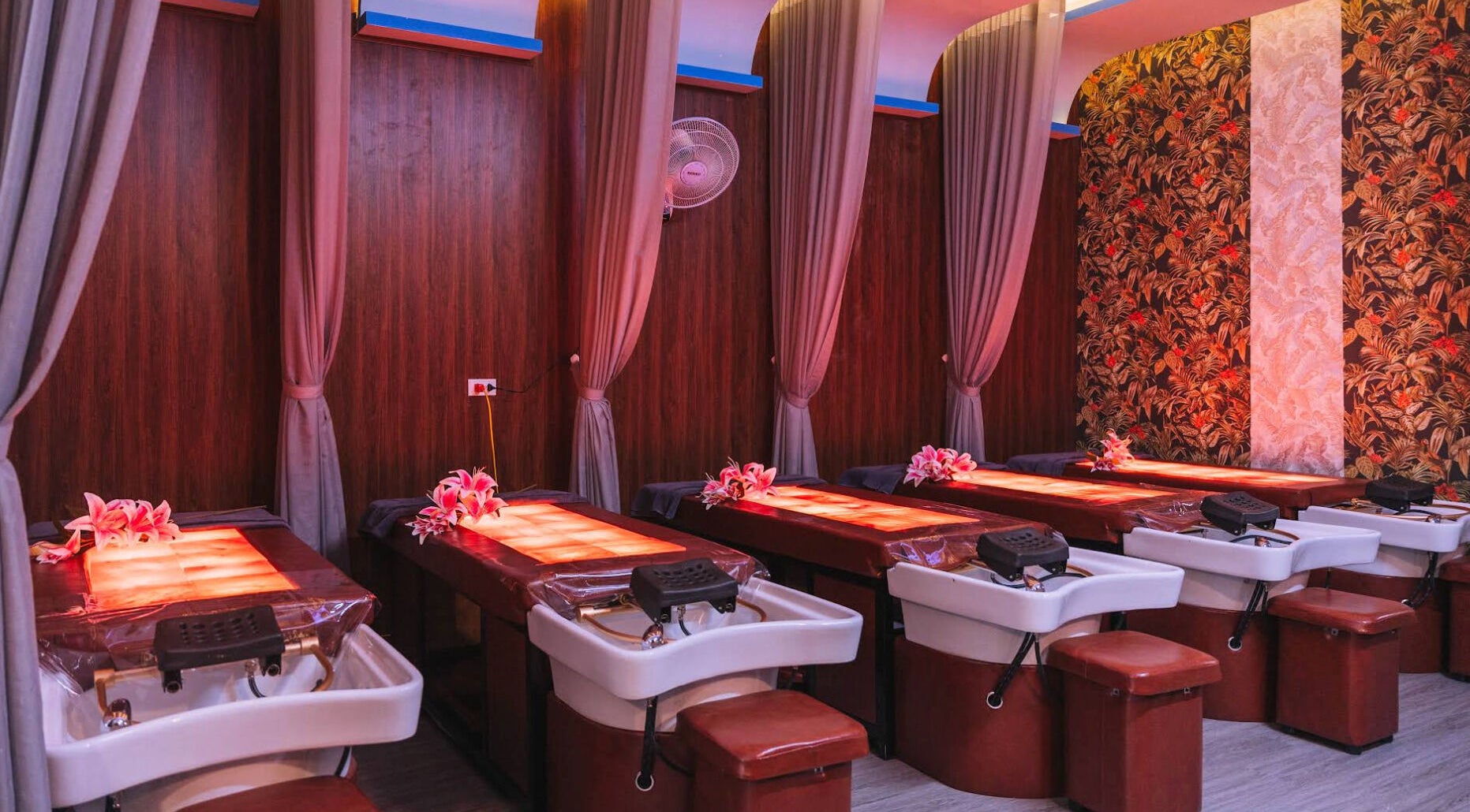 Luxurious massage tables at Solis Spa, Đà Nẵng, VN, adorned with flowers and warm lighting.