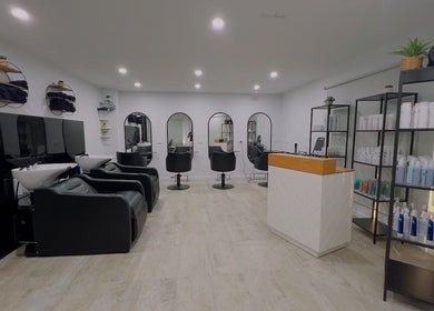 Modern salon interior of Kondethestylist in Melbourne, Victoria, AU, featuring stylish black chairs and shelves.