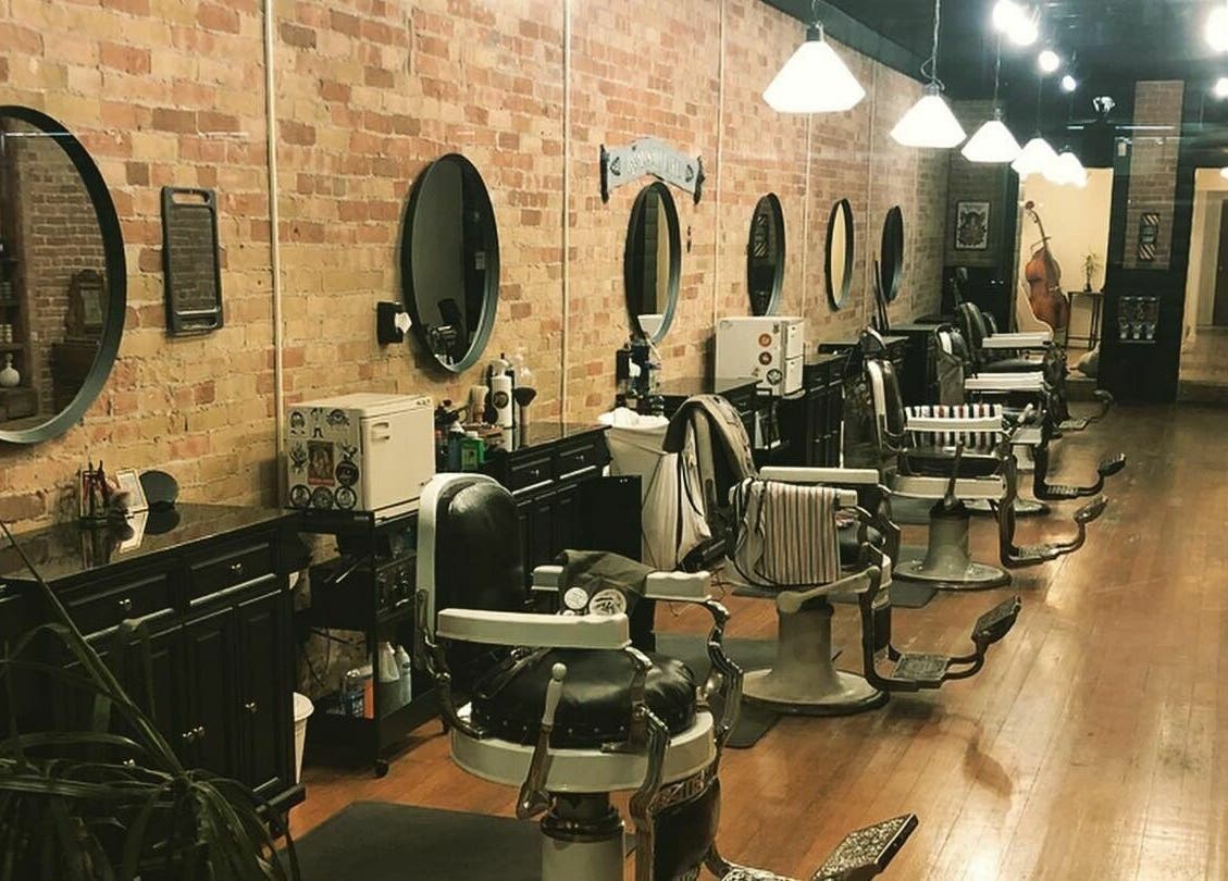 Interior of The Man Barber LLC in Provo, Utah, US featuring vintage barber chairs and rustic decor.