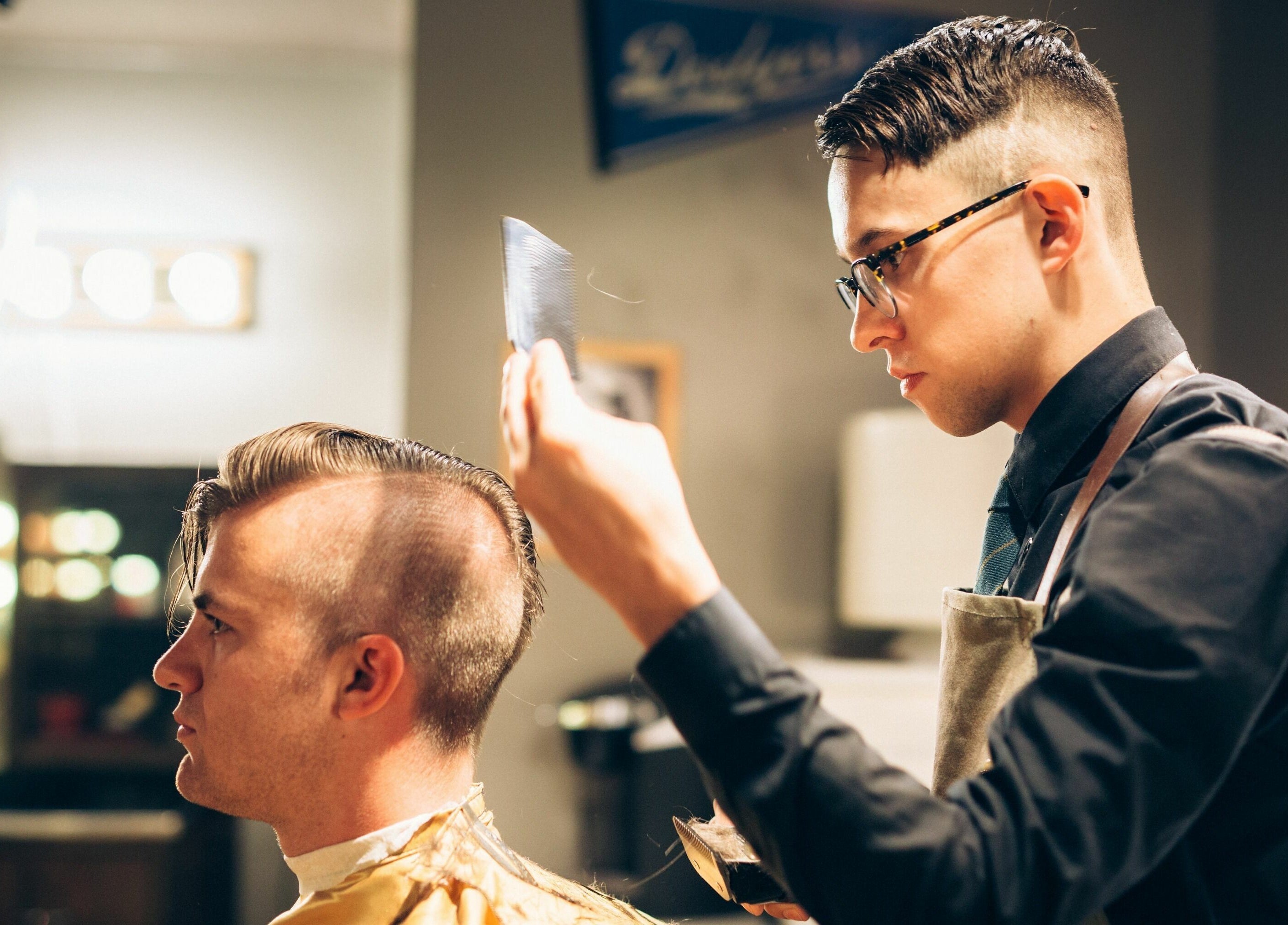 Professional barber styling hair at The Man Barber LLC in Provo, Utah, US. Modern haircut techniques in action.