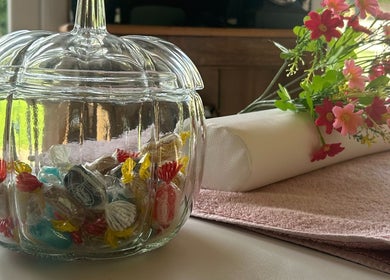 Glass jar of candies with flowers and towel at KTS Beauty, East Harling, England, GB.