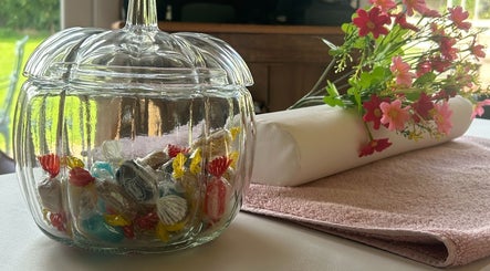Glass jar of candies with flowers and towel at KTS Beauty, East Harling, England, GB.