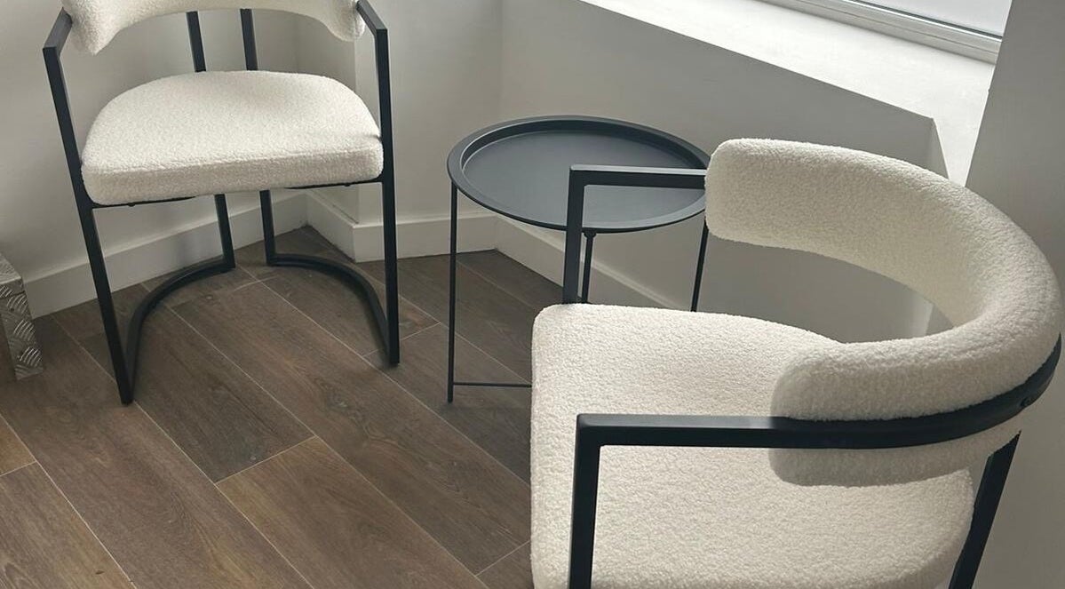 Modern seating arrangement at Aka Beauty, Glasgow, Scotland, GB, featuring sleek chairs and a round table.
