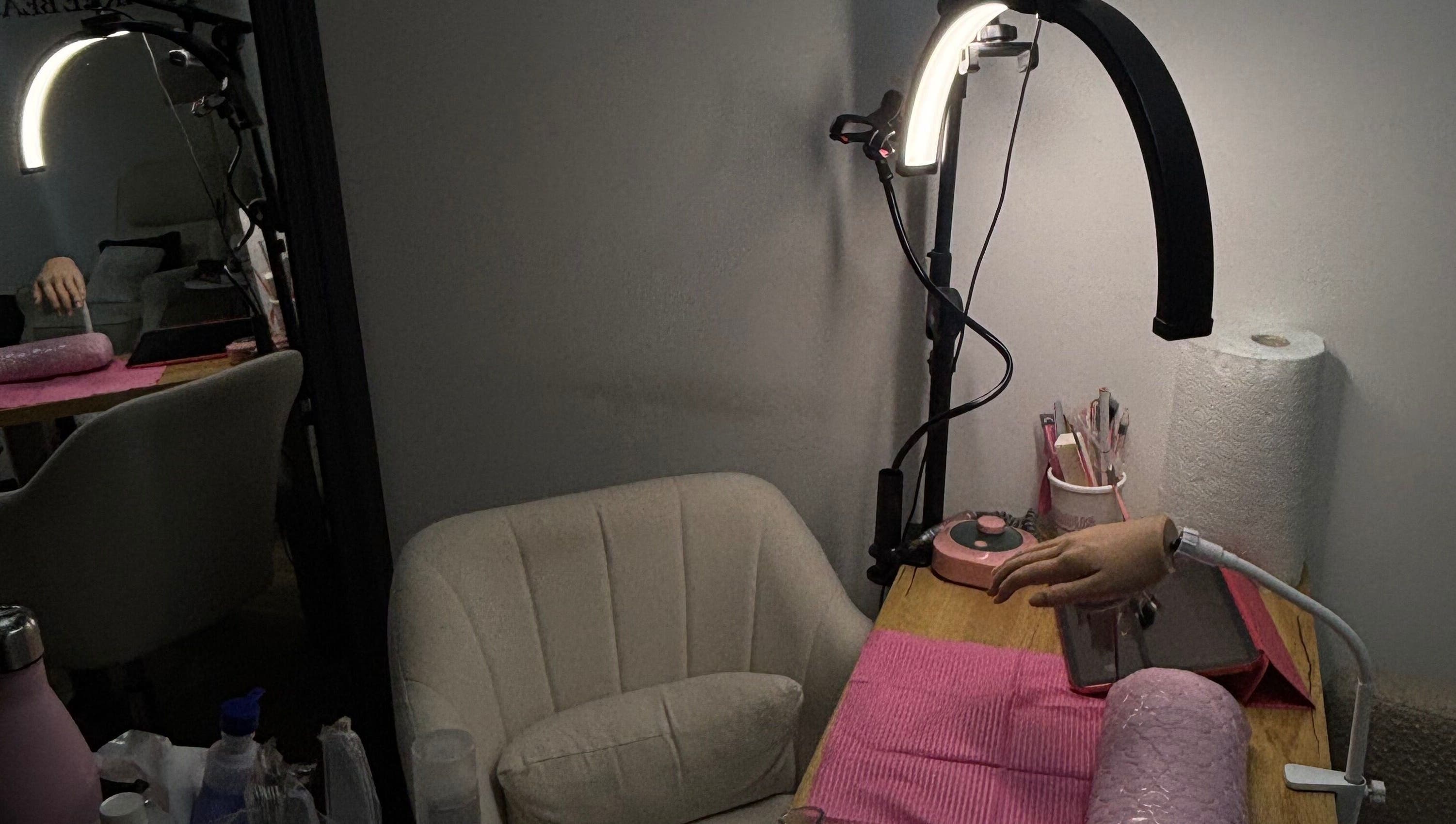 Cozy nail station at JenellaNailedIt in London, England, GB, featuring manicure tools and a plush chair.