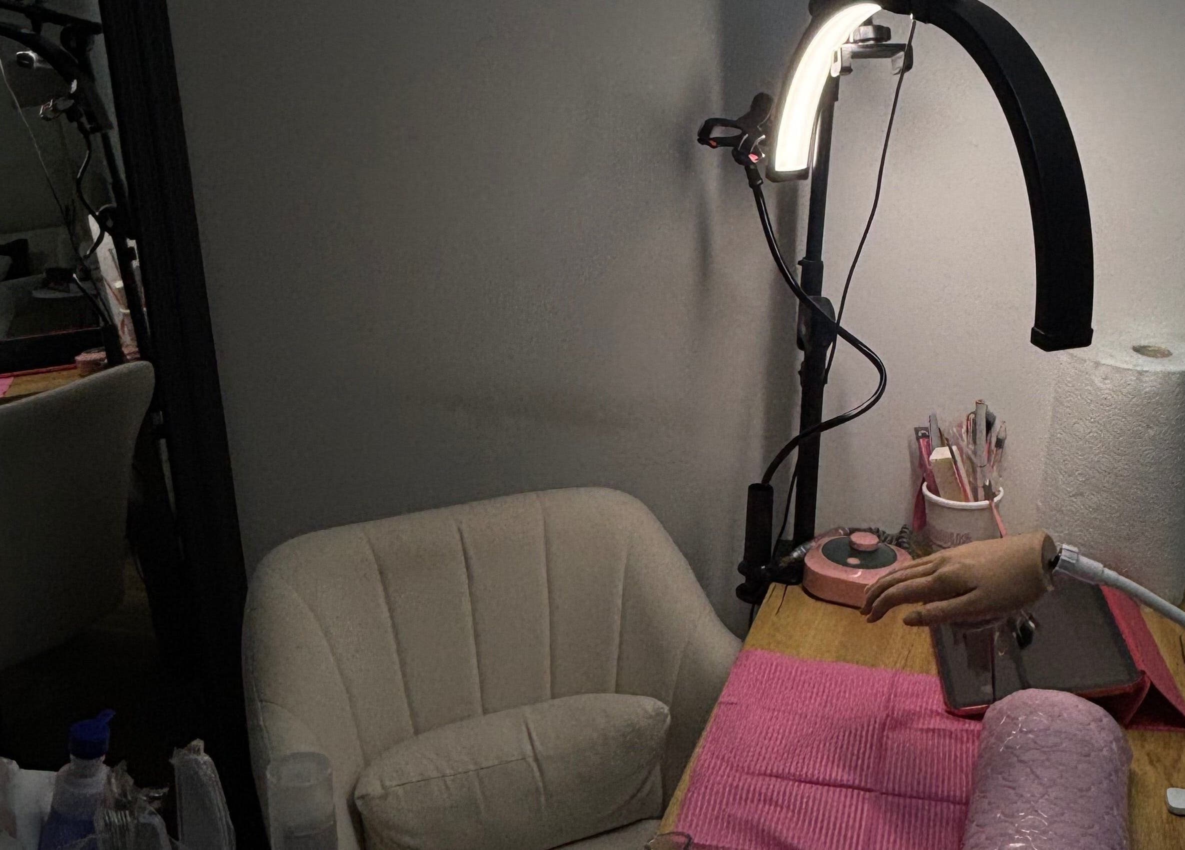 Cozy nail station at JenellaNailedIt in London, England, GB, featuring manicure tools and a plush chair.
