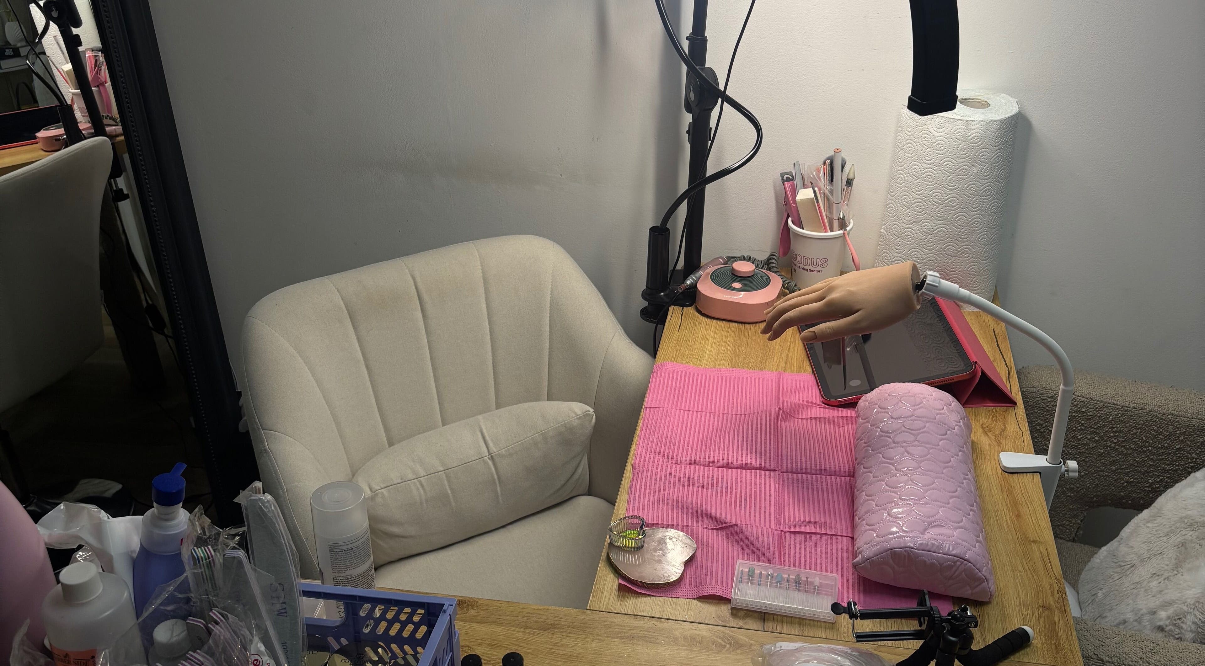 Professional manicure station at JenellaNailedIt, London, England, GB, featuring tools and a manicure dummy hand.