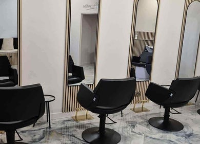 Chic salon interior at Aphrodite in Stirling, Scotland, GB, features sleek black chairs and stylish mirrors.