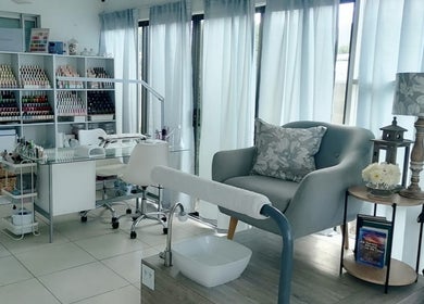 Modern interior of Dream Skin Aesthetics in Stanford, Western Cape, ZA, showcasing a chic nail station and cozy seating.