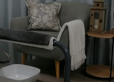 Cozy relaxation corner at Dream Skin Aesthetics, Stanford, Western Cape, ZA with plush chair and foot spa.