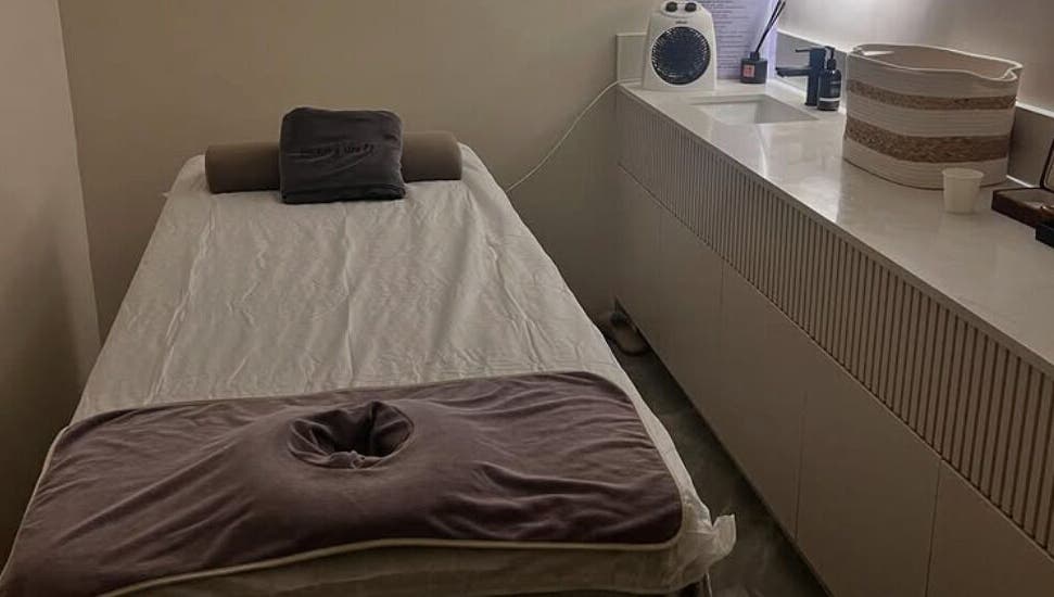 A serene massage room at Living Well Massage Town Hall in Sydney, New South Wales, AU with a cozy massage table.