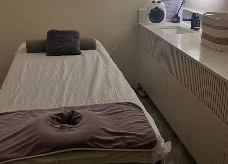 A serene massage room at Living Well Massage Town Hall in Sydney, New South Wales, AU with a cozy massage table.