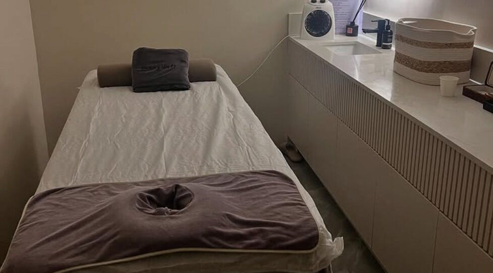 A serene massage room at Living Well Massage Town Hall in Sydney, New South Wales, AU with a cozy massage table.