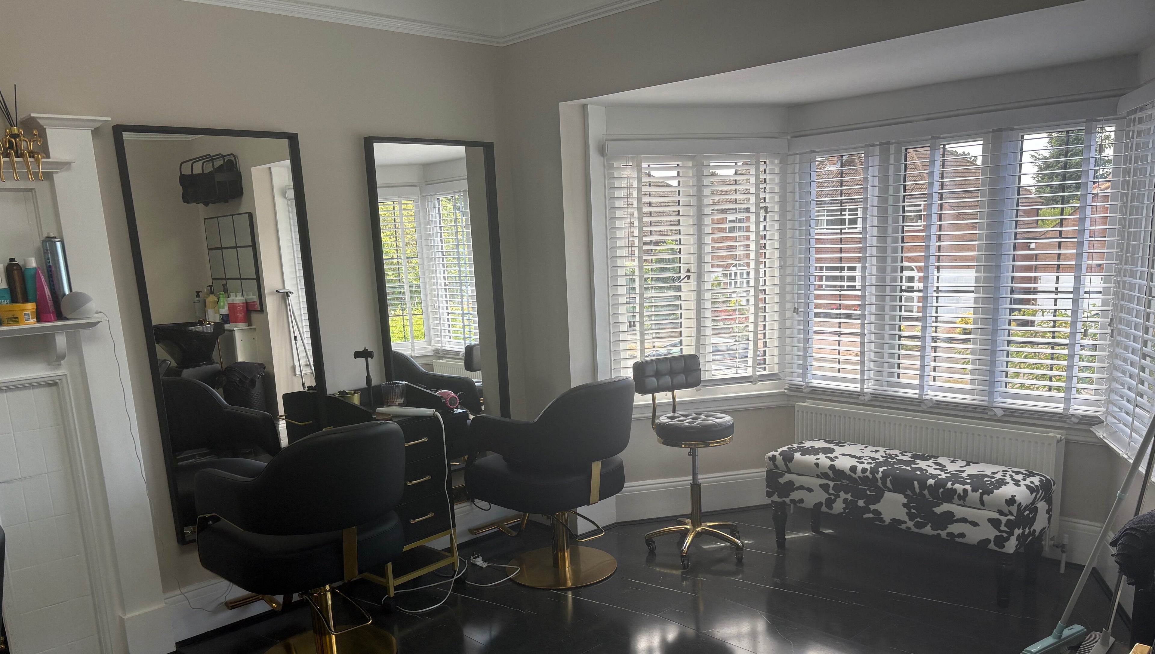 Elegant interior of Hair by Hannah salon in Bentley Heath, England, GB with stylish chairs and large mirrors.