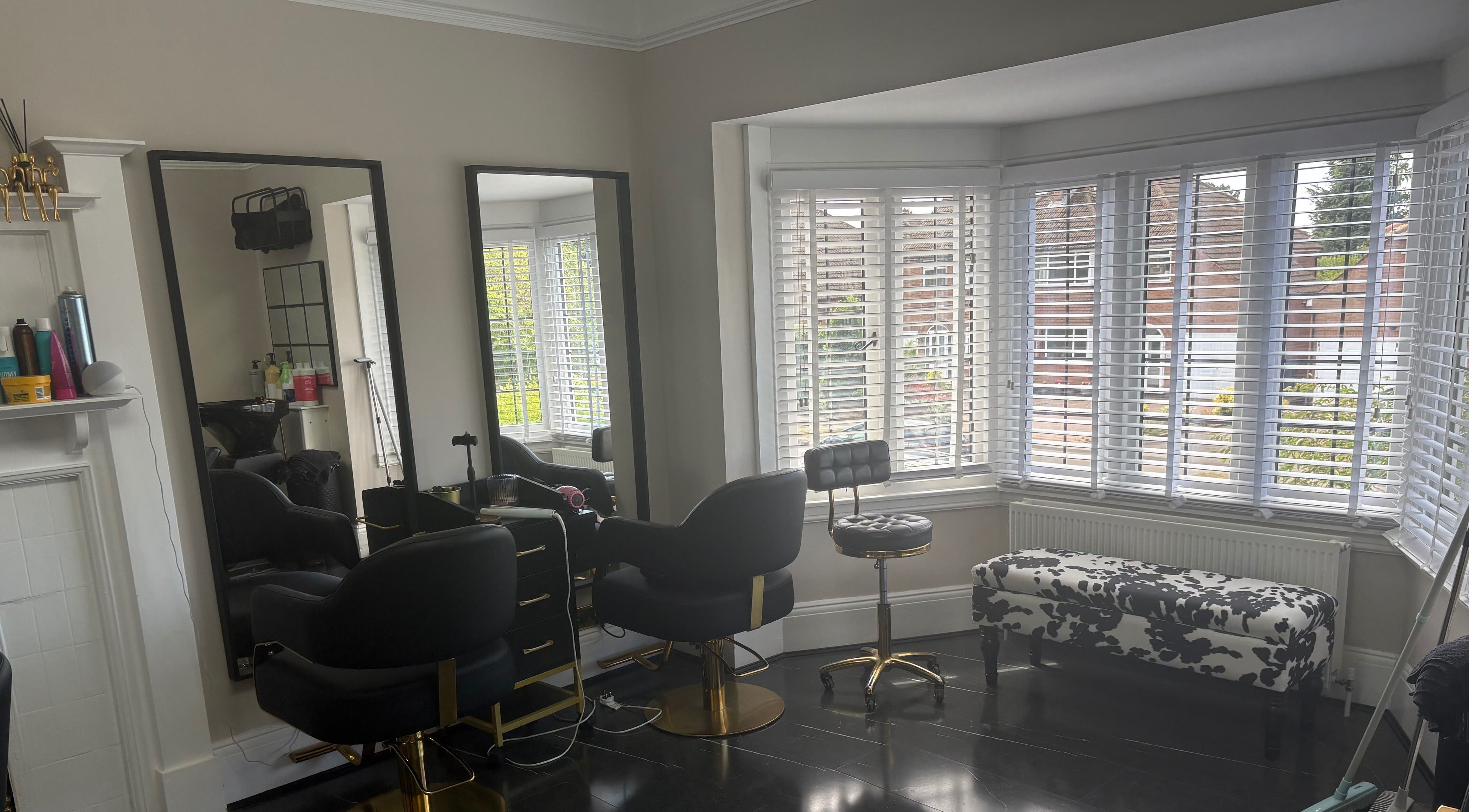 Elegant interior of Hair by Hannah salon in Bentley Heath, England, GB with stylish chairs and large mirrors.