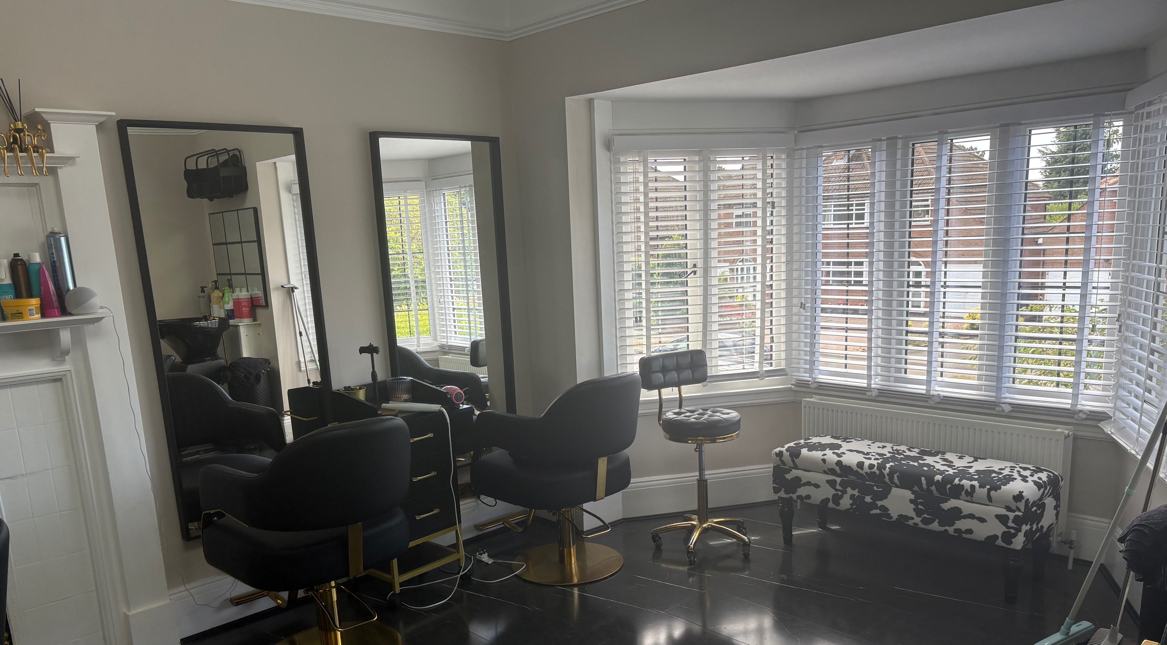 Elegant interior of Hair by Hannah salon in Bentley Heath, England, GB with stylish chairs and large mirrors.