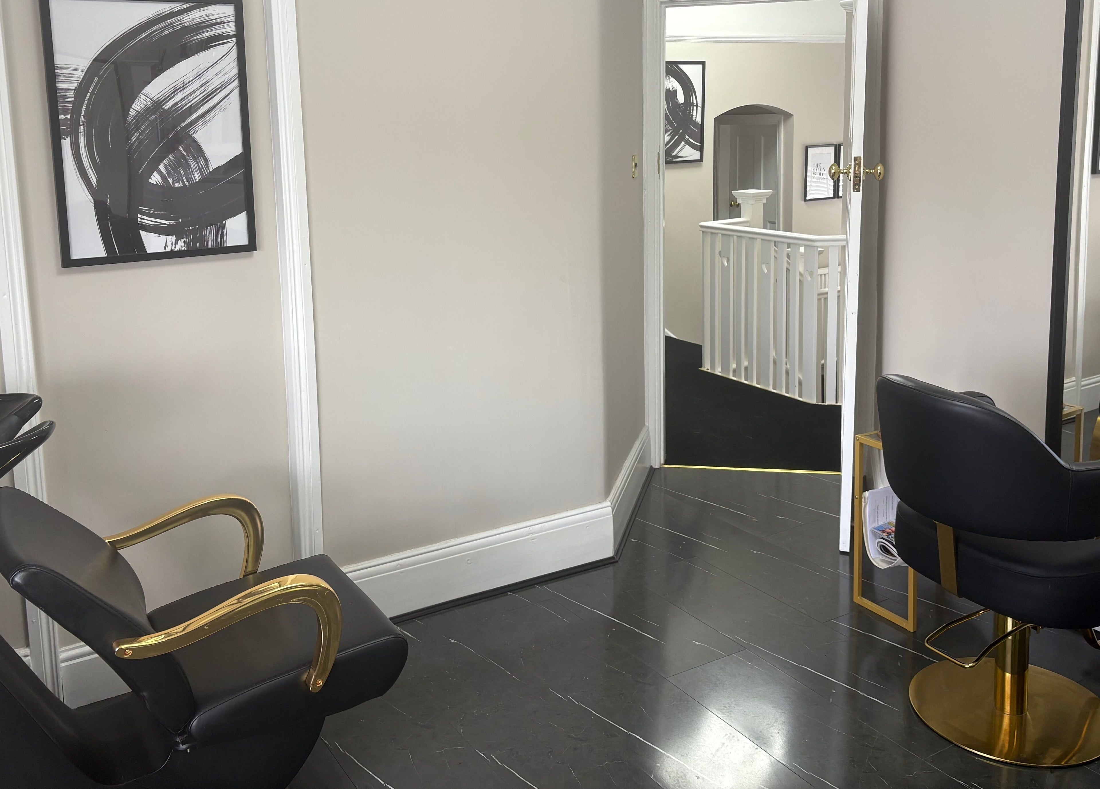 Elegant salon interior at Hair by Hannah in Bentley Heath, England. Modern black chair and gold accents adorn the space.
