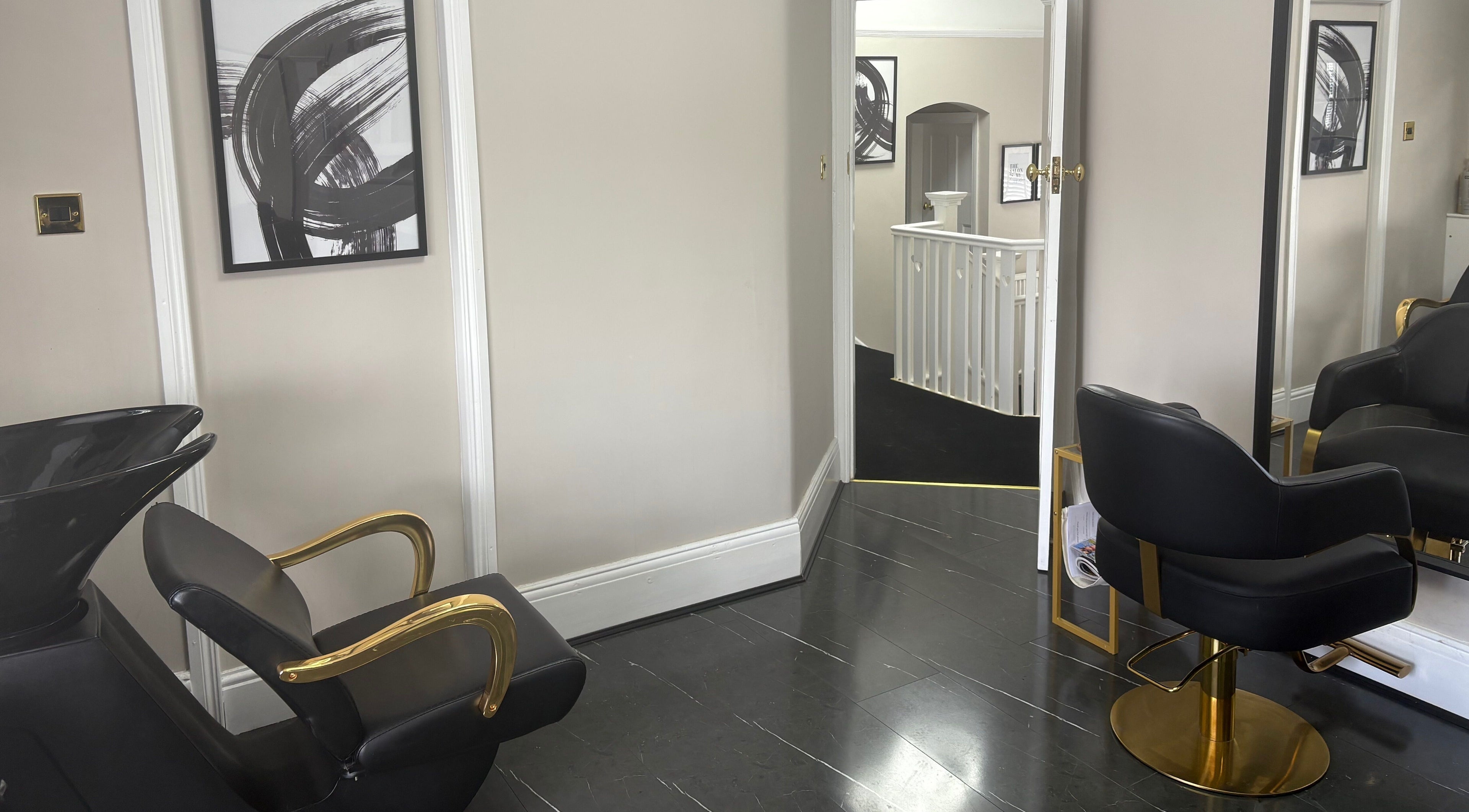 Elegant salon interior at Hair by Hannah in Bentley Heath, England. Modern black chair and gold accents adorn the space.