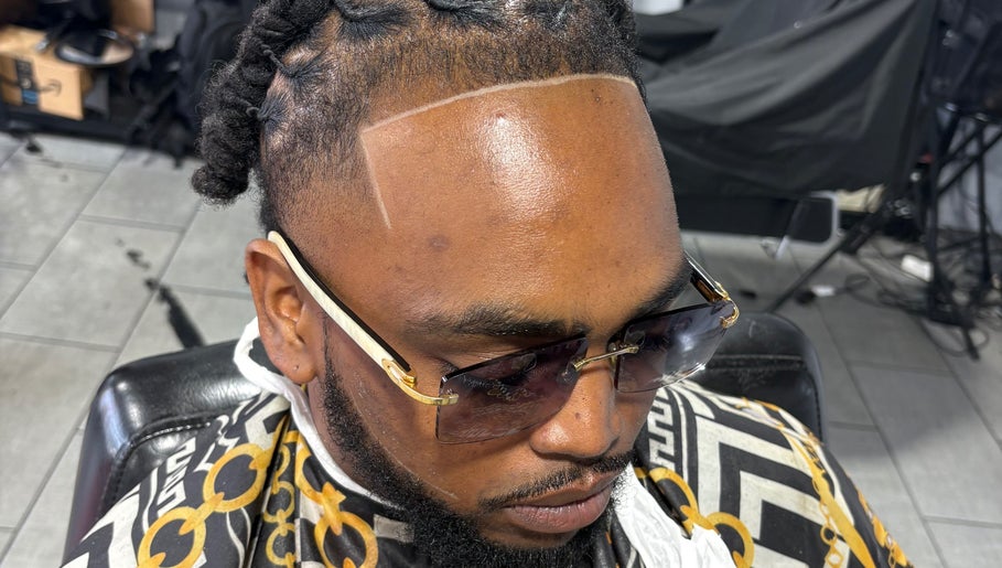 Man with braided hairstyle and sunglasses at Faded Barbershop in Detroit, Michigan, US.