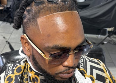 Man with braided hairstyle and sunglasses at Faded Barbershop in Detroit, Michigan, US.