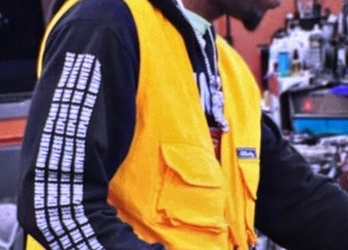 Barber in yellow vest at Faded Barbershop, Detroit, Michigan, US, focusing on a haircut.