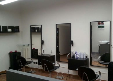 Interno elegante di Fashion Colorist a Poviglio, Emilia-romagna, IT, con postazioni ben arredate e specchi moderni.