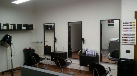 Interno elegante di Fashion Colorist a Poviglio, Emilia-romagna, IT, con postazioni ben arredate e specchi moderni.