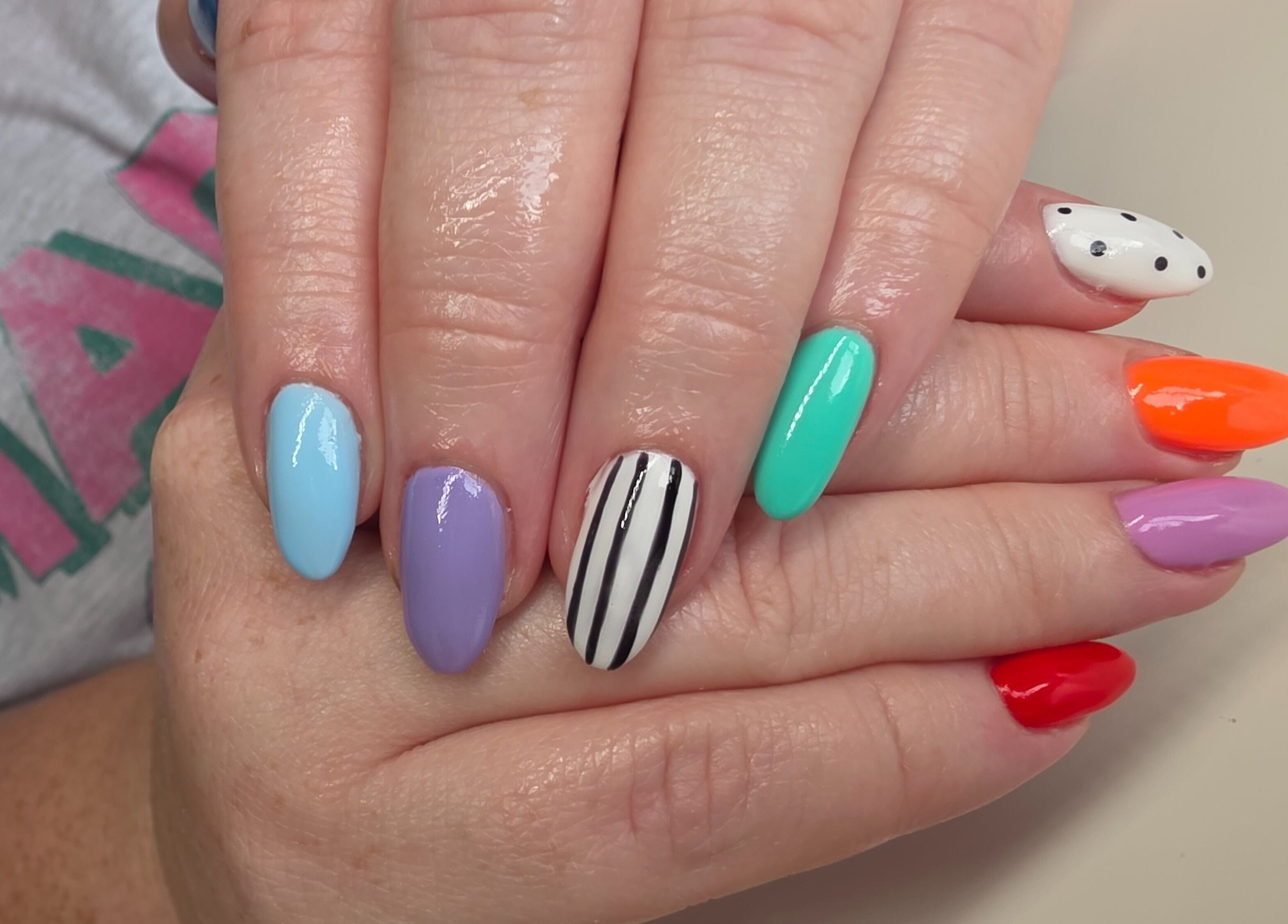Colorful nail art at Nail Divas, Newport, Wales, GB, featuring vivid designs on manicured hands.