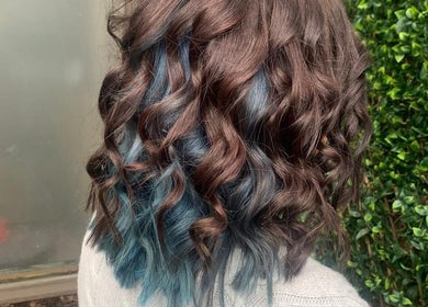 Vibrant curly hair with blue highlights at Studio H Aesthetics, Barbers & Hair in Norwich, England, GB.
